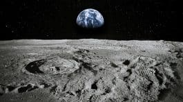 surface of moon showing footprints with view of earth in the background