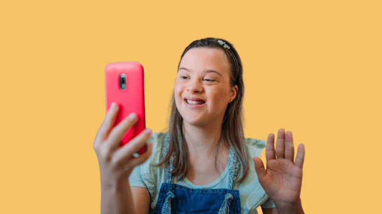 Young woman waves to someone on a mobile phone